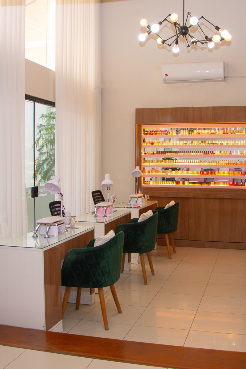 Interior de The Beauty House con mesas de manicure y pared de esmaltes